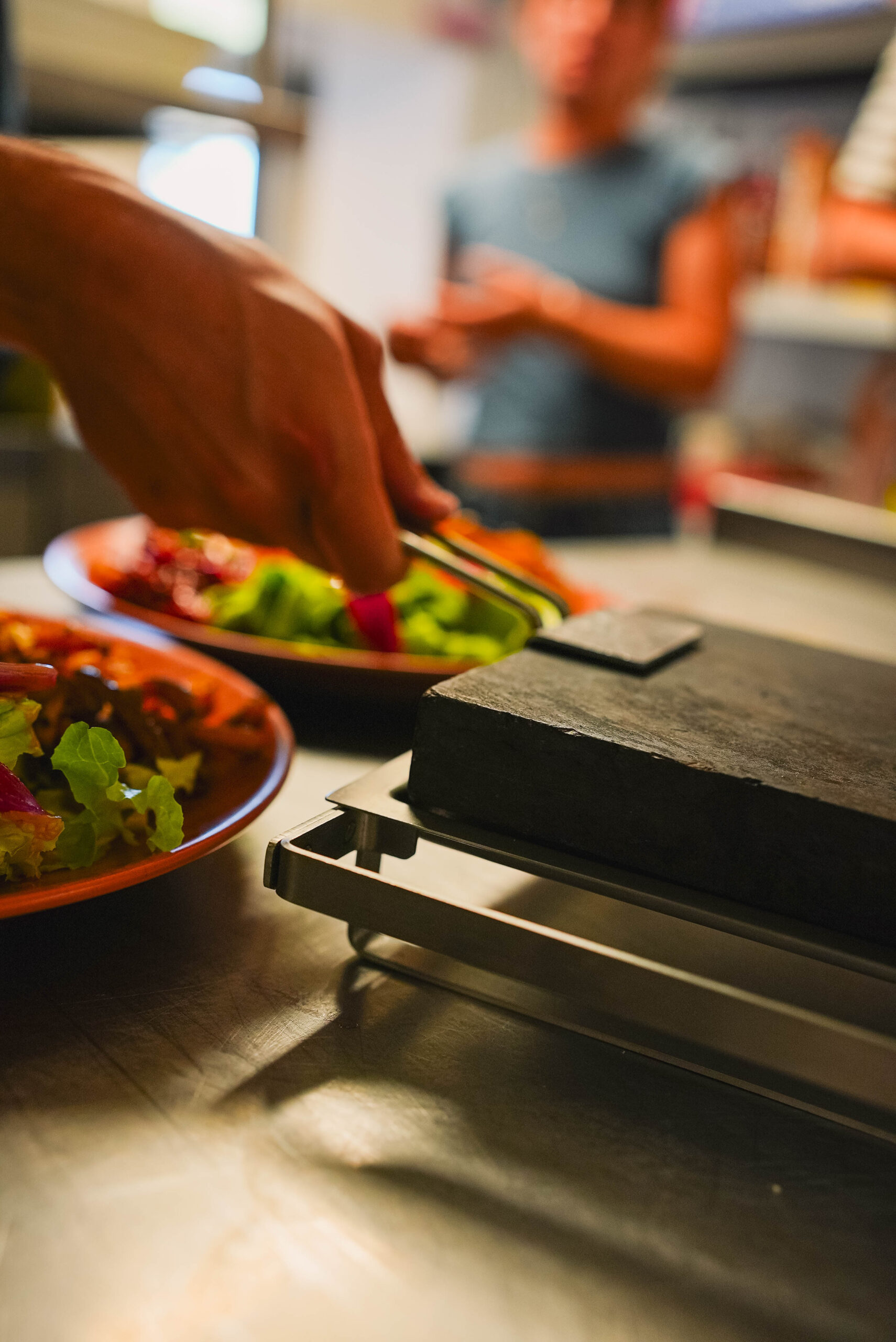 Personne manipulant une pierrade au restaurant Chez Charlemagne